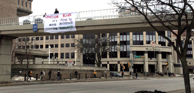 A group of SLAC members unveils a poster encouraging the chancellor to support Bangladeshi workers’ rights Tuesday.